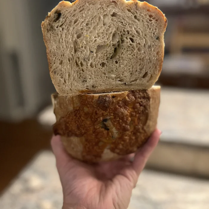 A cut loaf of green chile and pepper jack sourdough, showing the crumb