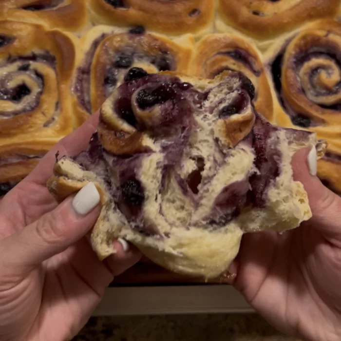 A lemon blueberry swirl pulled open to show the fruit inside